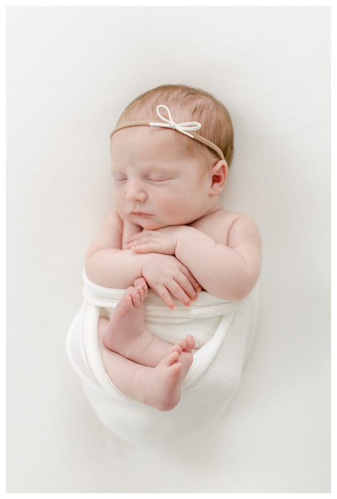 newborn baby swaddled in white blanket photographed by Philadelphia Newborn Photographer Tara Federico