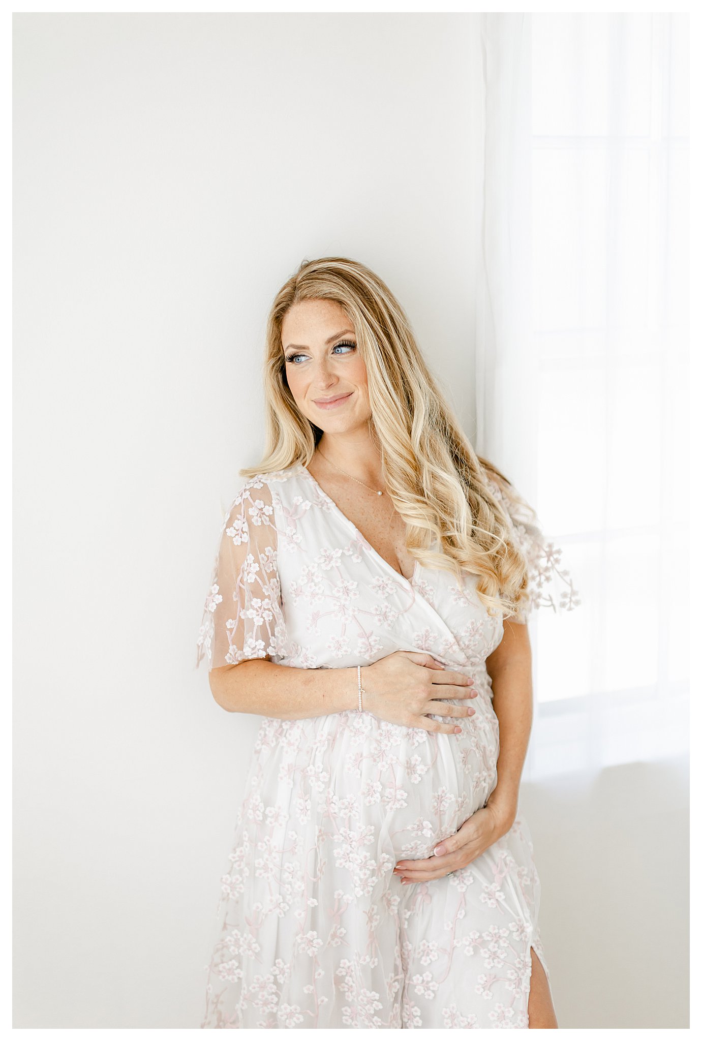 gorgeous expectant mom wearing a pink and white floral dress photographed by Tara Federico