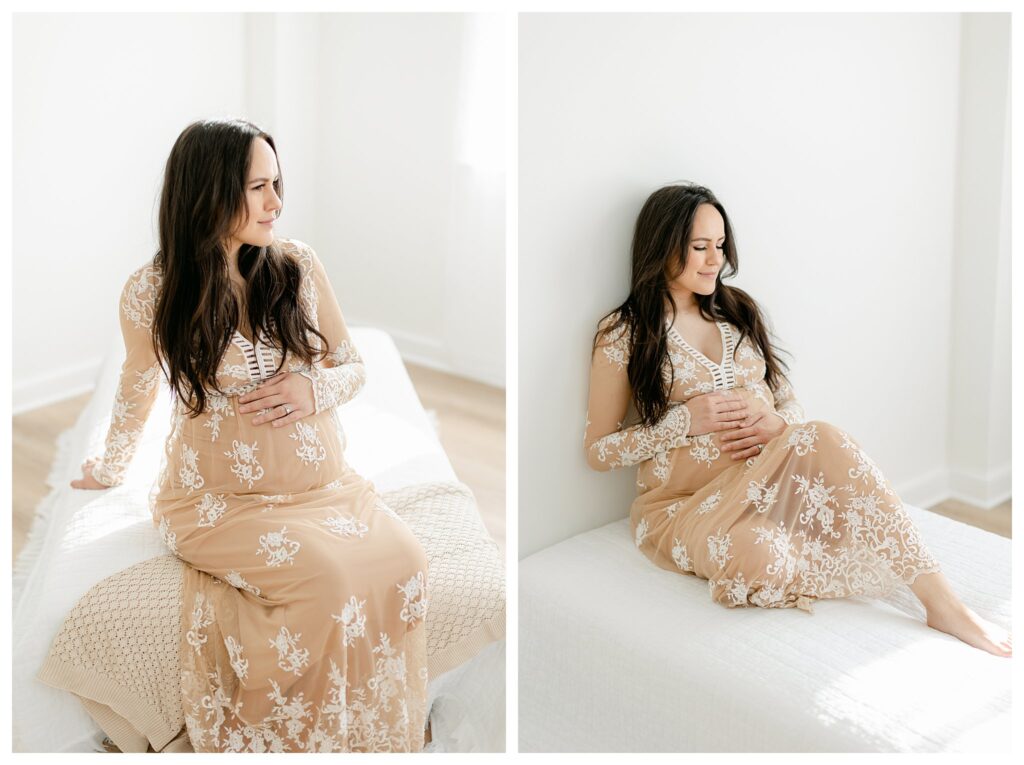 A beautiful pregnant mom sitting on a bed holding onto her belly during her maternity session in Tara Federico Photography's studio
