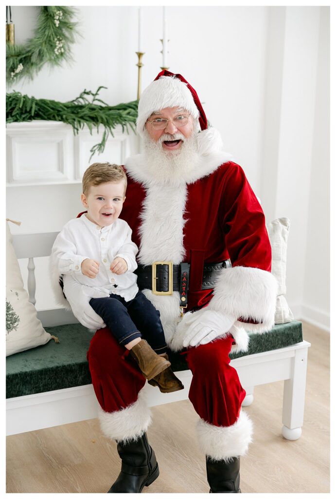 Toddler boy sitting on Santa Claus' lap during South Jersey Santa Pictures photographed by Tara Federico Photography