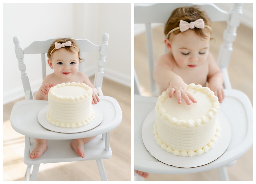 sweet baby girl sitting in a white wooden high chair diving into her birthday cake