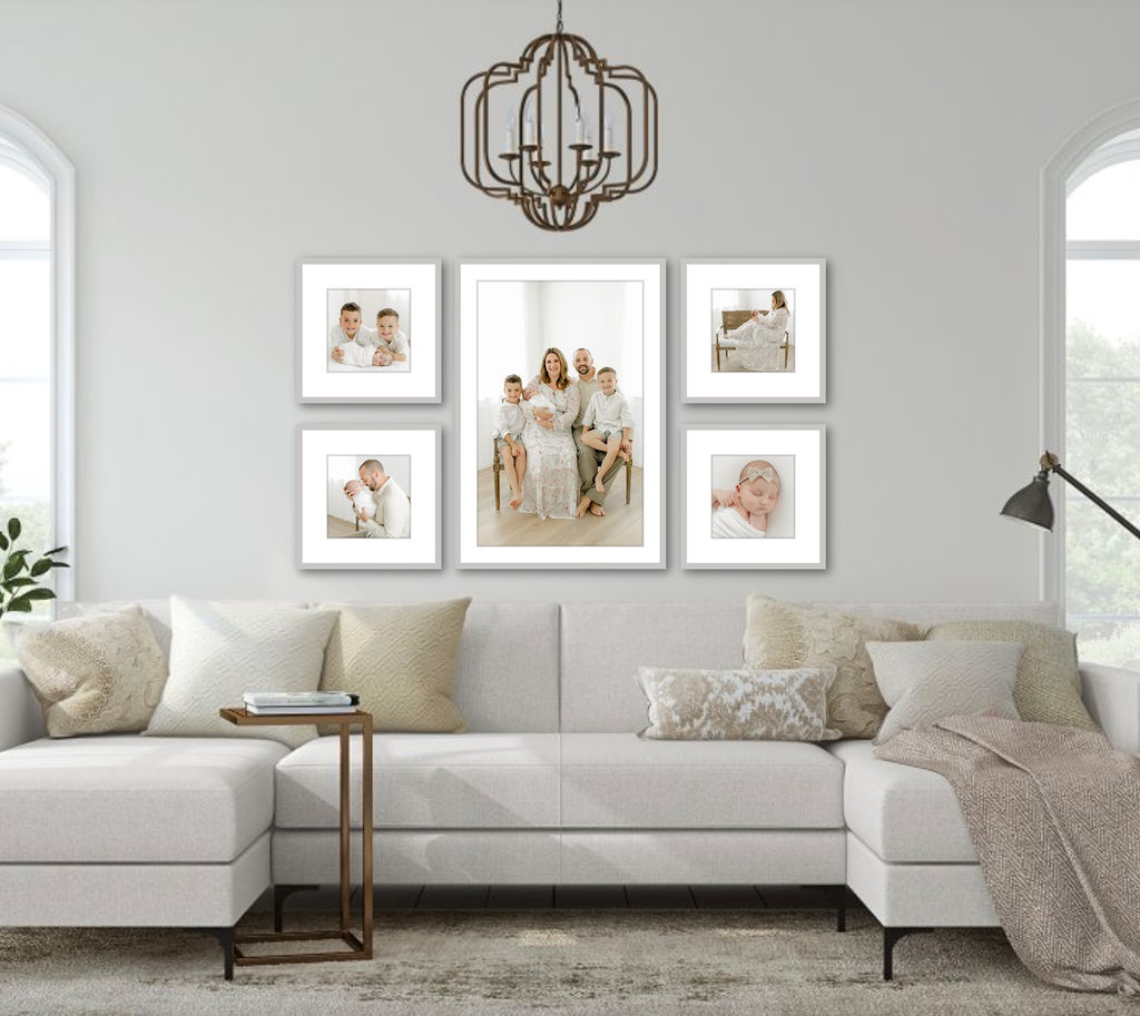 Framed family and newborn portraits hang on a wall above a couch for charleston sc home decor