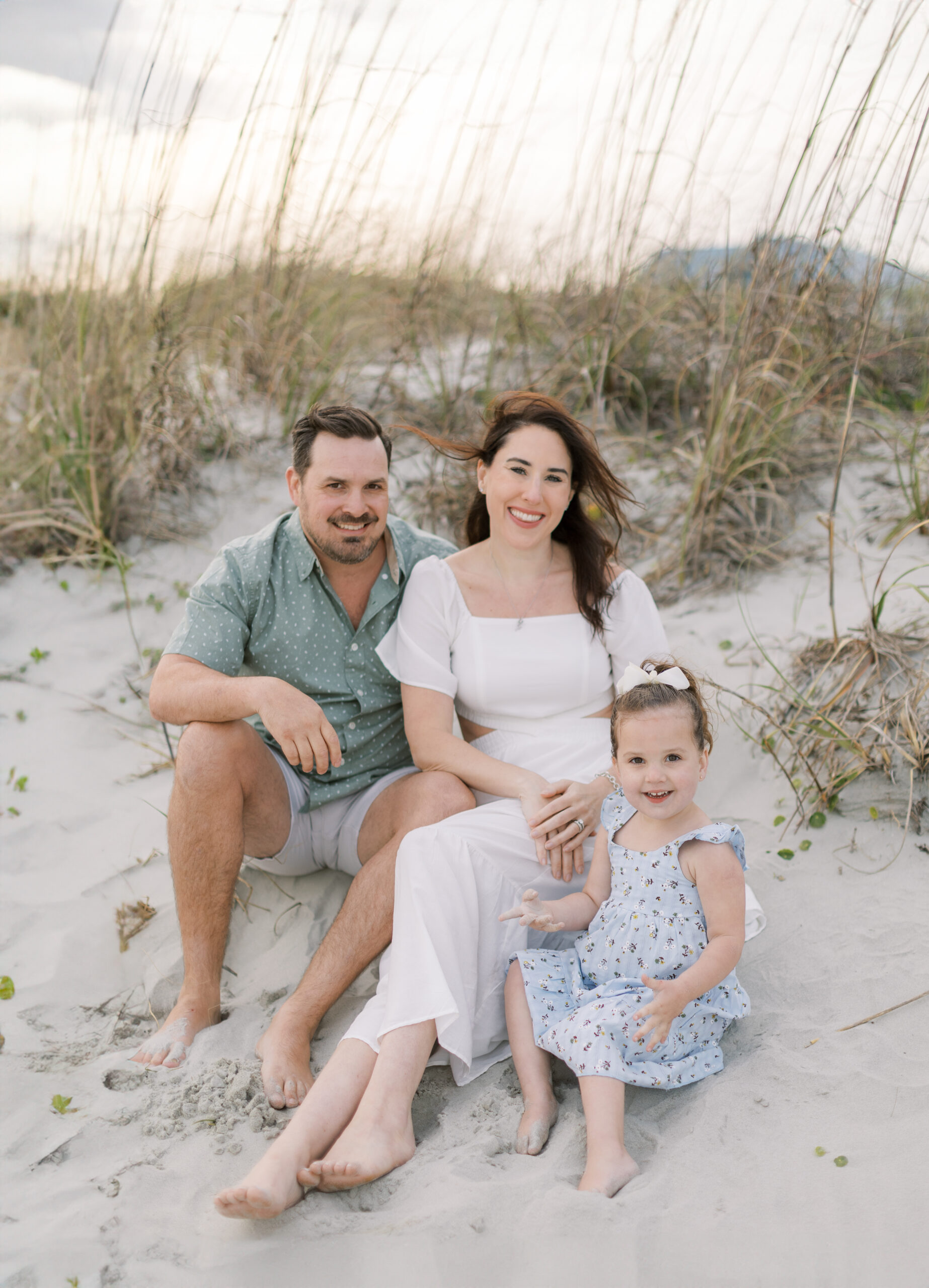 Family in pastel-colored outfits posing for a photo session at Isle of Palms beach